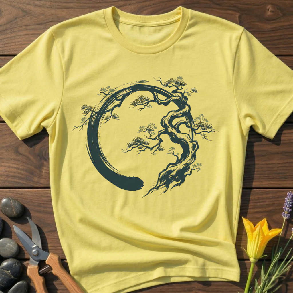 Yellow t-shirt with black tree design on a wooden surface with scissors and flowers.